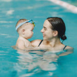 Little cute baby boy. Mother with son. Family playing in a water.